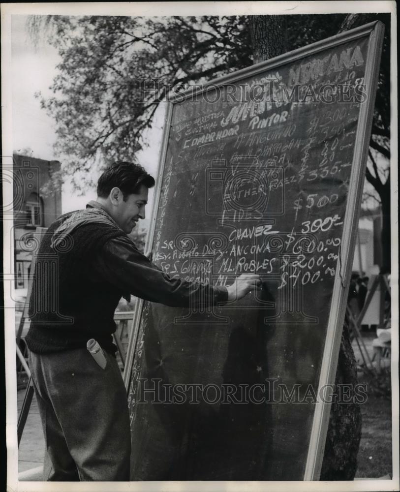 1957 Press Photo Man adds up art sales for the Sullivan Art Show. - Historic Images