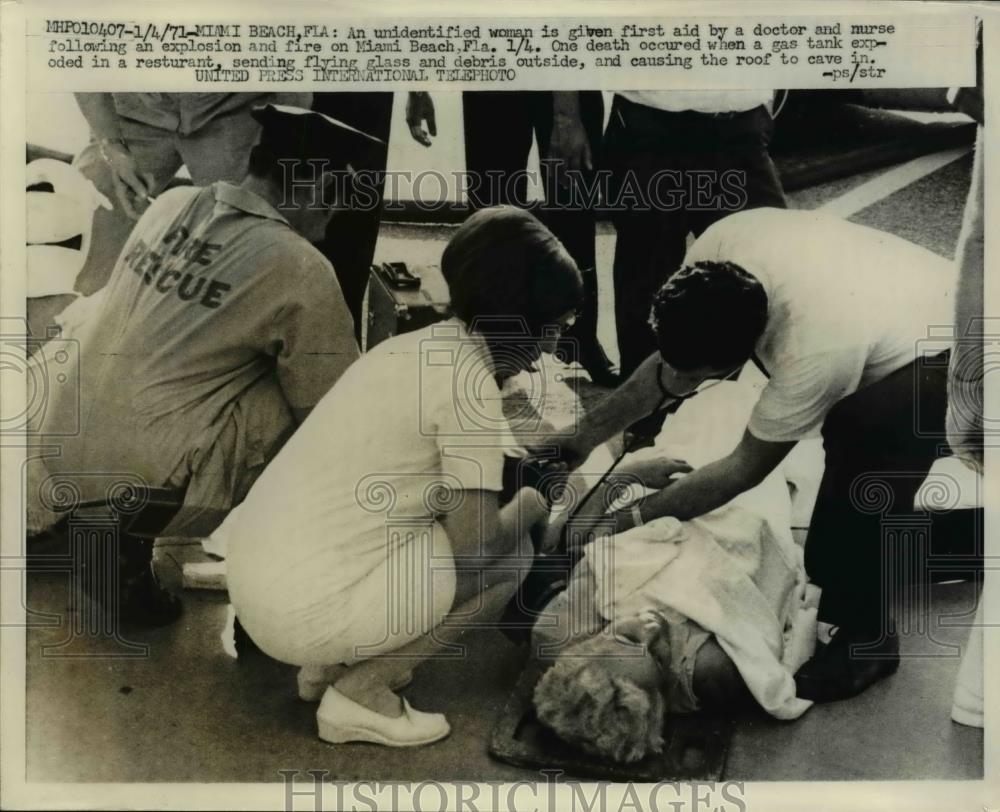 1971 Press Photo Woman given first aid following an explosion on Miami Beach - Historic Images