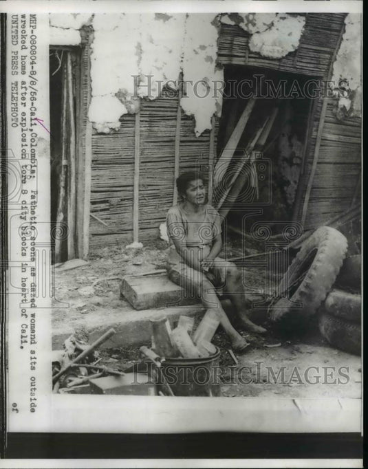 1956 Press Photo Dazed woman sits outside home after explosion in heart of Cali - Historic Images