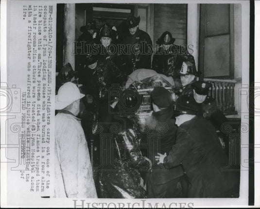 1955 Press Photo Firefighters carry out 1 of the occupants of Lyn lodging house - Historic Images