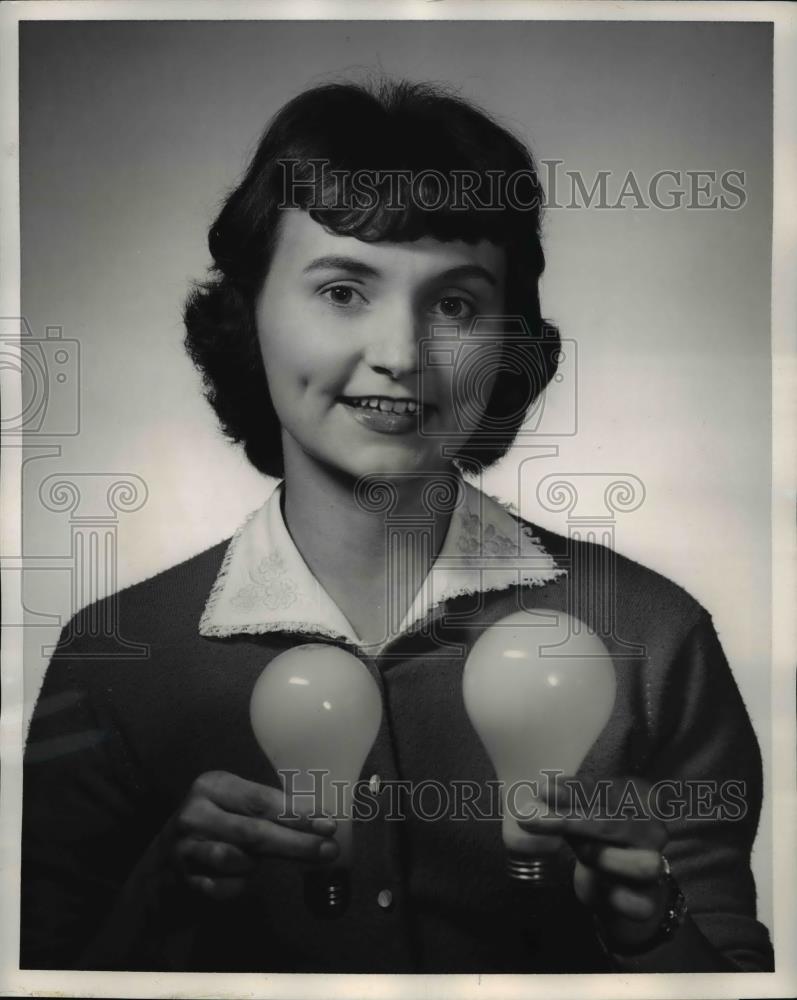 Press Photo Woman holding small bulb with more light, announced by Westinghouse - Historic Images