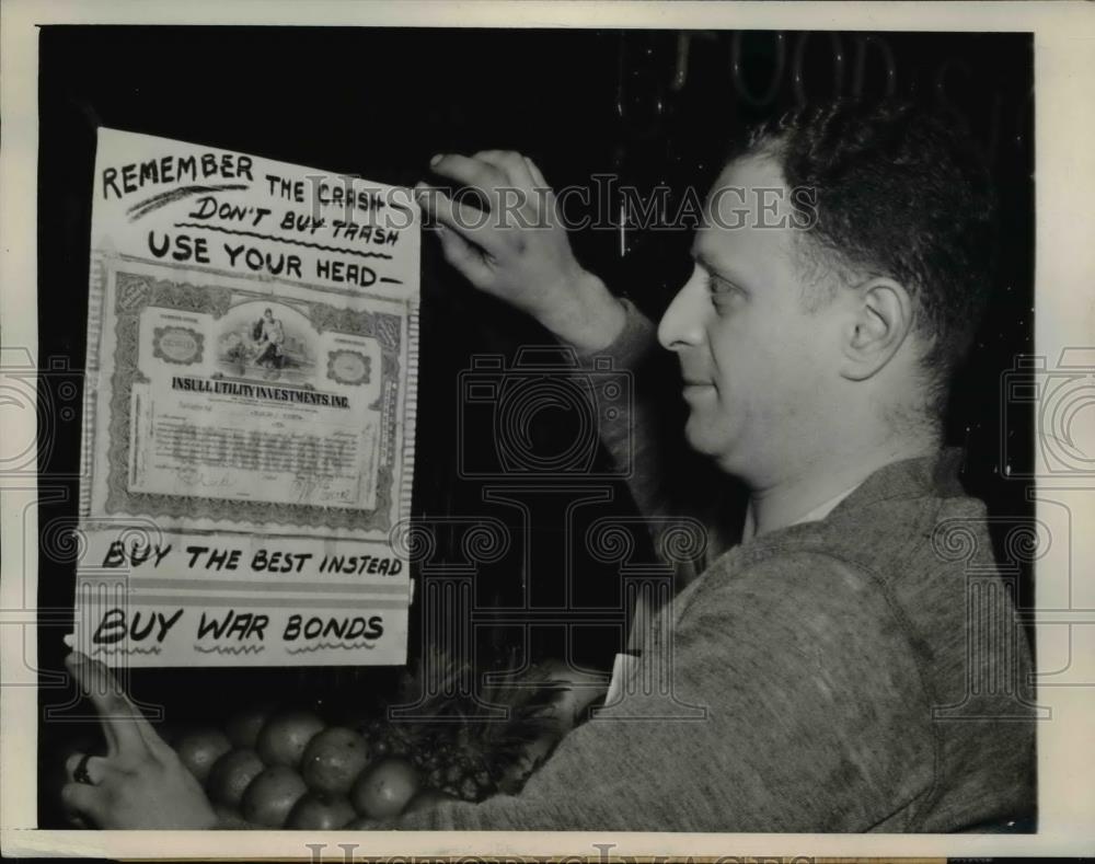 1944 Press Photo Chicago grocer, Eugene Eisman displays a poster for war bond - Historic Images