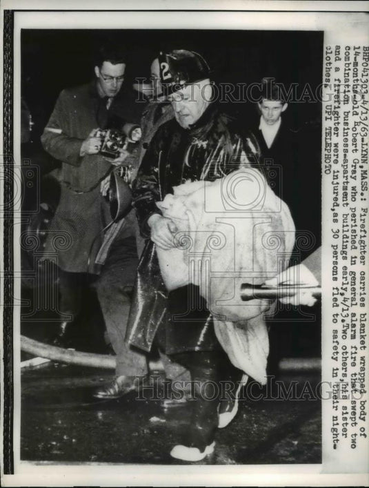 1963 Press Photo Firefighter carries blanket wrapped body of 14 months old - Historic Images
