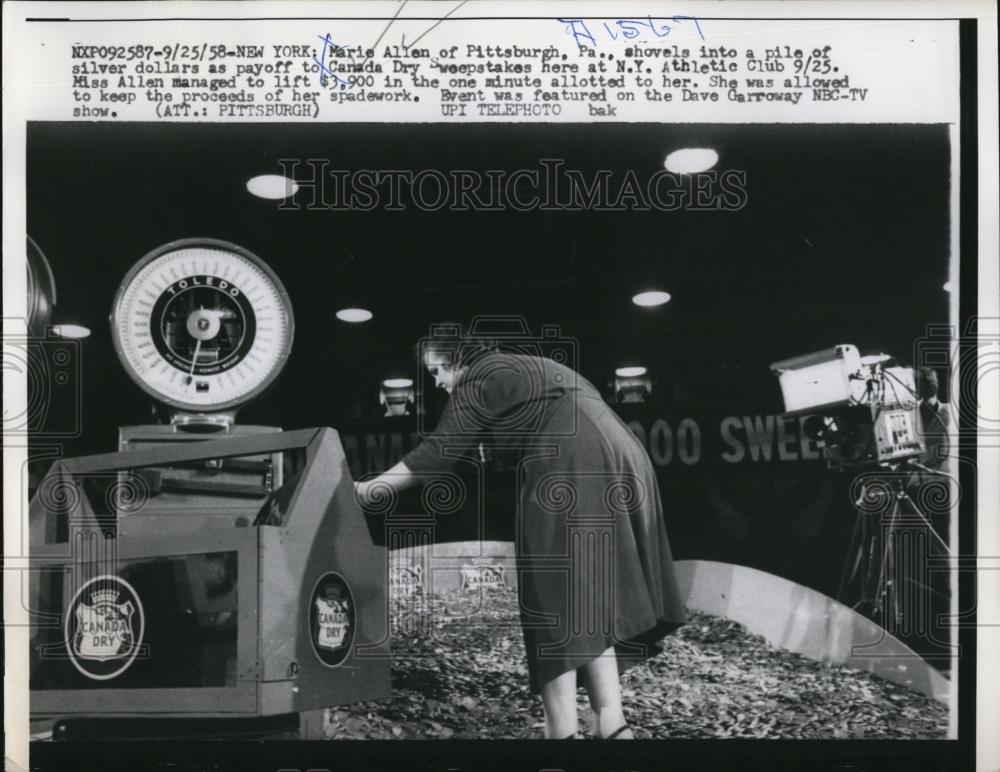 1958 Press Photo Marie Allen shovels silver dollars to Canada Dry Sweepstakes - Historic Images