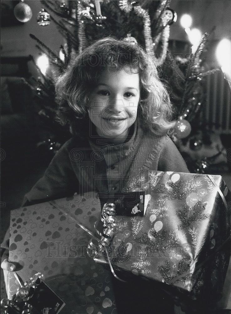 1988 Press Photo Girl Holding Christmas Presents - Historic Images