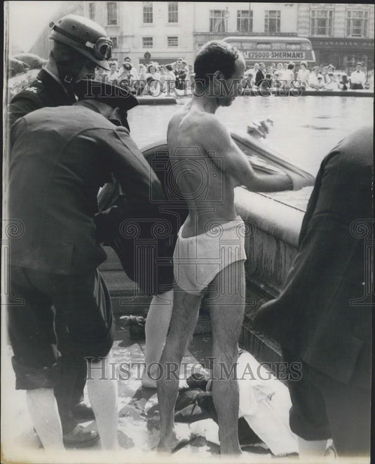 1959 Press Photo  police get the man to dress himself after his 'dip' - Historic Images