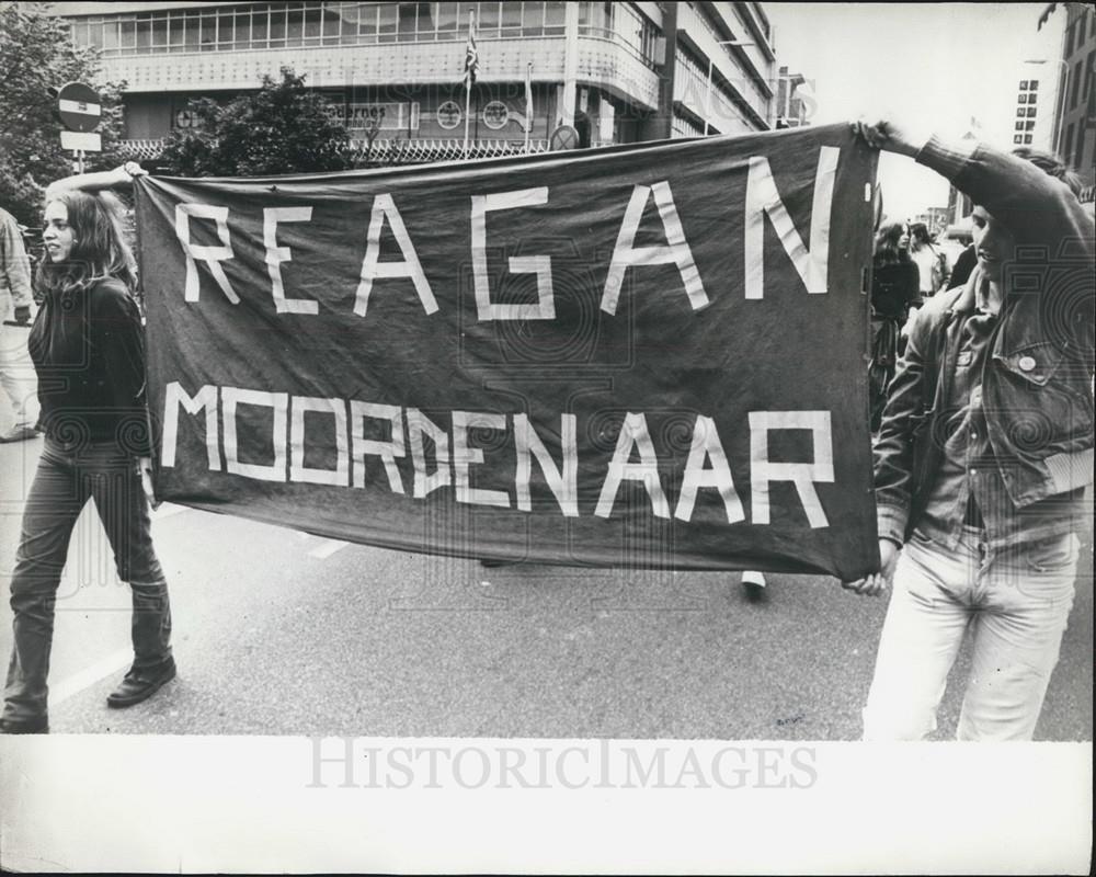 1981 Press Photo Demonstrators with a banner with the words &quot;Reagan Killer&quot;. - Historic Images