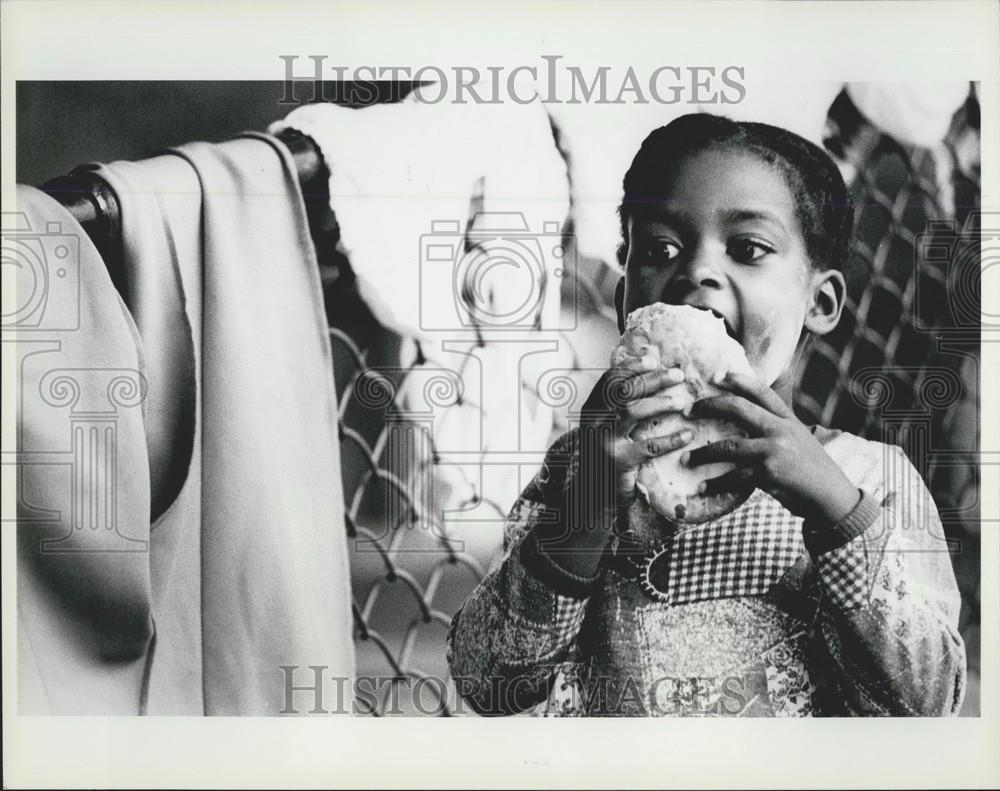 Press Photo Young Cuban Refugee Licking Icing From Honeybun - Historic Images