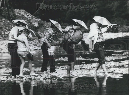 Press Photo West Germany Visitors Wearing Umbrella Hats Walking On Rocks - Historic Images
