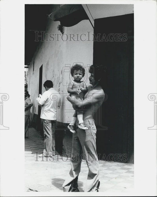 1981 Press Photo Young Man Holding Small Child Managua Nicaragua Streets - Historic Images