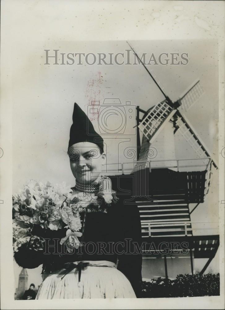 1953 Press Photo Dutch Woman With Tulips Windmill Background Holland - Historic Images