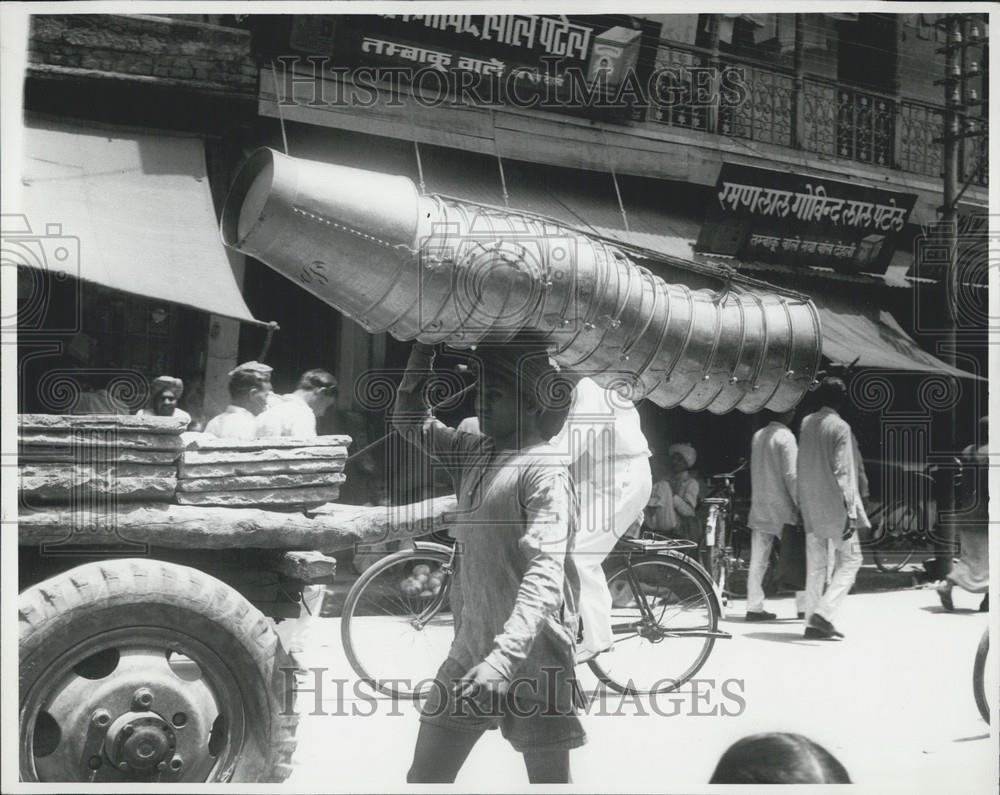 Press Photo A delivery man in Madras, India, easily carries 17 buckets on his he - Historic Images