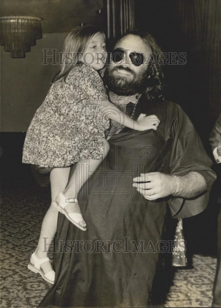 Press Photo Greek Singer Dehis Roussos Holding Little Girl Wearing Sunglasses - Historic Images