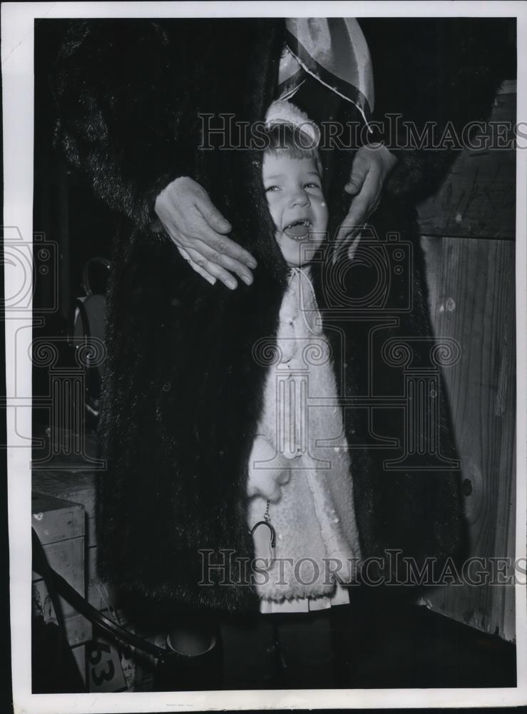 1962 Press Photo Riitta Mustonen hiding under her mothers fur coat. - Historic Images