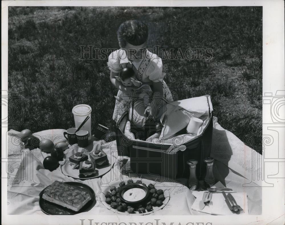 1956 Press Photo Little picnicker unpacking both hot and cold food from her bag - Historic Images