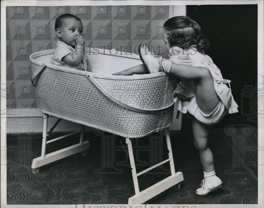 1958 Press Photo Melinda climbs aboard while Martin chews his thumb - Historic Images