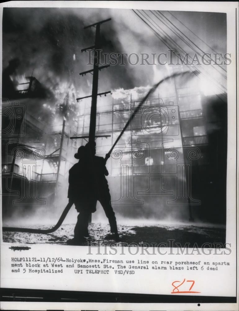 1964 Press Photo Fireman use line on rear porch to fight the general alarm fire - Historic Images