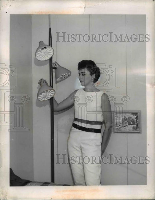 1959 Press Photo Miss Jackie Furnival inspects a 3 spotlights in a pole light - Historic Images