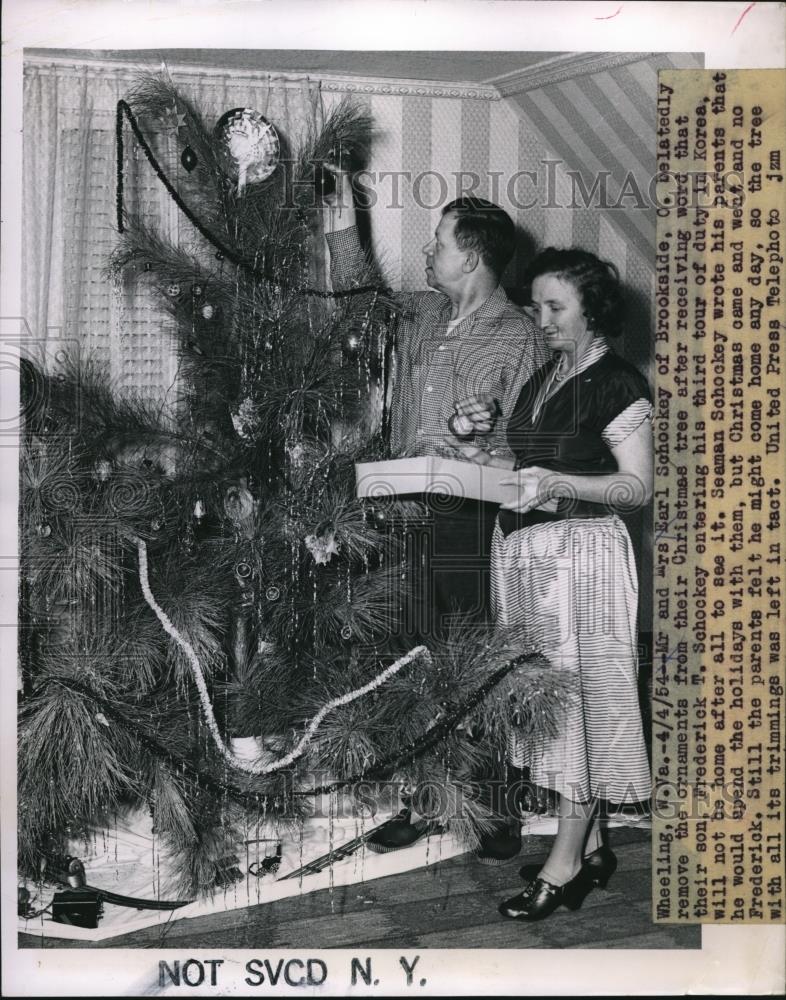 1954 Press Photo Mr &amp; Mrs Earl Schockey removes ornaments from Christmas tree - Historic Images