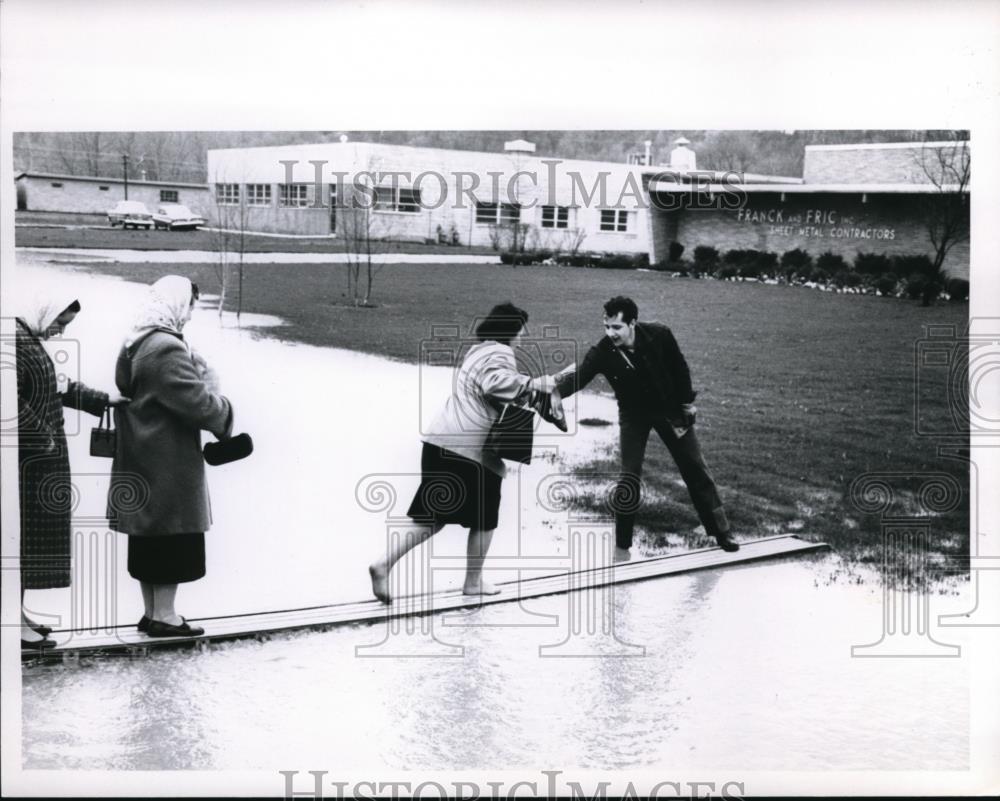 1961 Press Photo Man helps women over some floodwaters - Historic Images