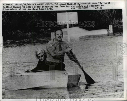 1969 Press Photo Policeman Maurice H. Ottovich, rows Lillian Hammer to - Historic Images