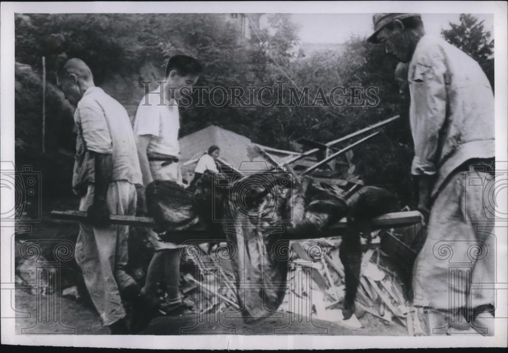 1950 Press Photo Volunteer workers remove a victim&#39;s body from a demolished home - Historic Images