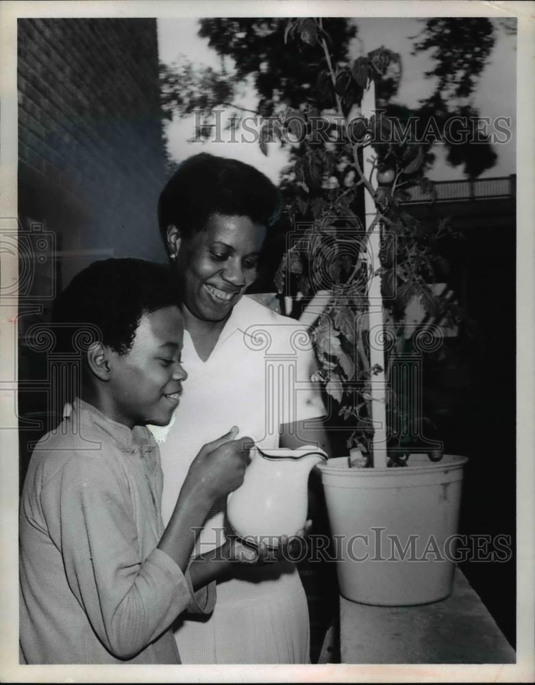 1969 Press Photo Mrs. H.M Singleton & son, Tony, watering a plant - Historic Images