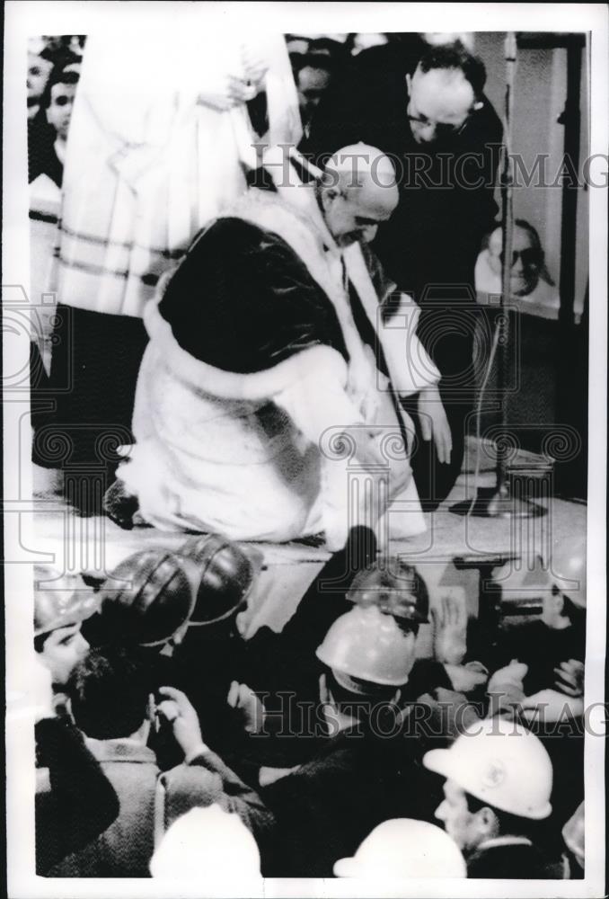 1968 Press Photo Pope Paul VI kneels down to shake hands with helmeted workers - Historic Images