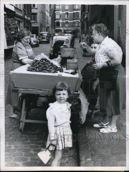 1959 Press Photo Mother & Child Eating Raw Mussels, Brussels Belgium Street - Historic Images