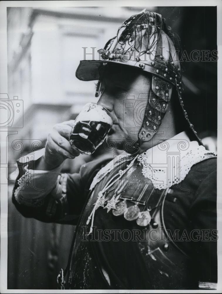 1961 Press Photo of man dressed as an English PIkeman drinking a beer. - Historic Images