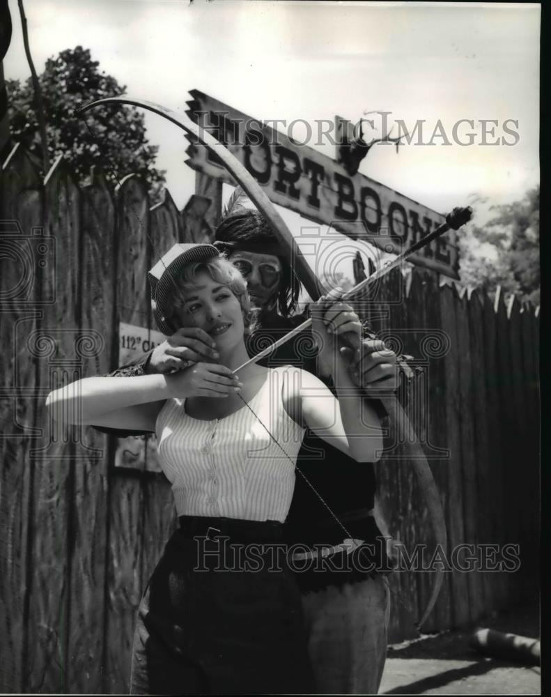 1961 Press Photo of Lisa Evans being taught how to fire a flaming arrow by an - Historic Images
