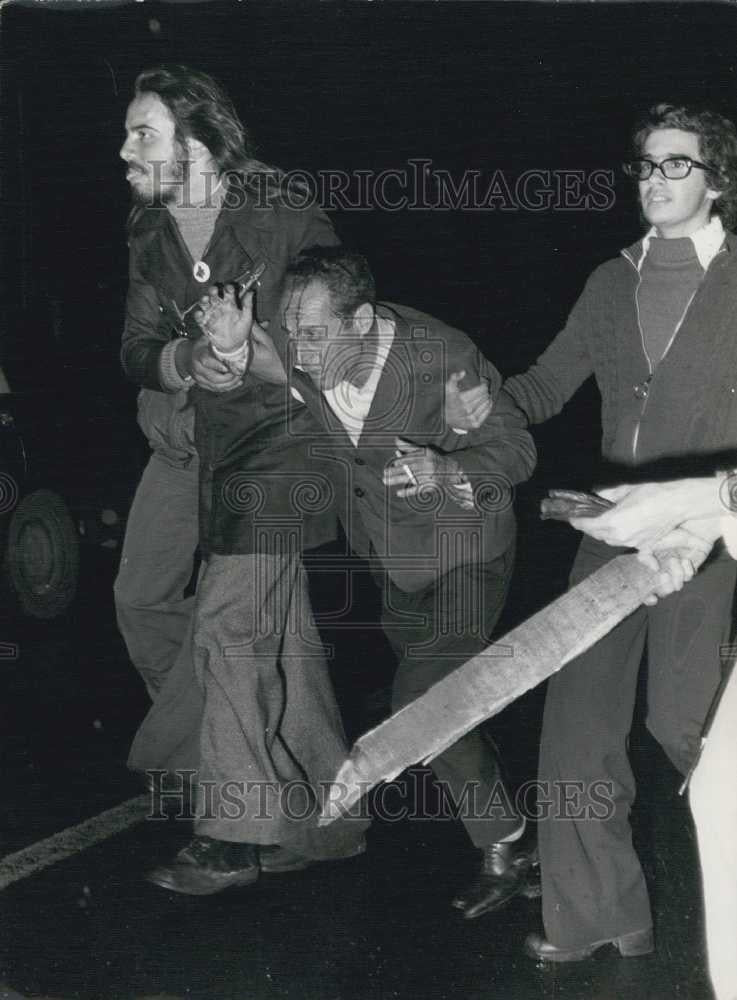 1975 Press Photo Angolan Refugees Assist Fellow Refugee in Rain France - Historic Images