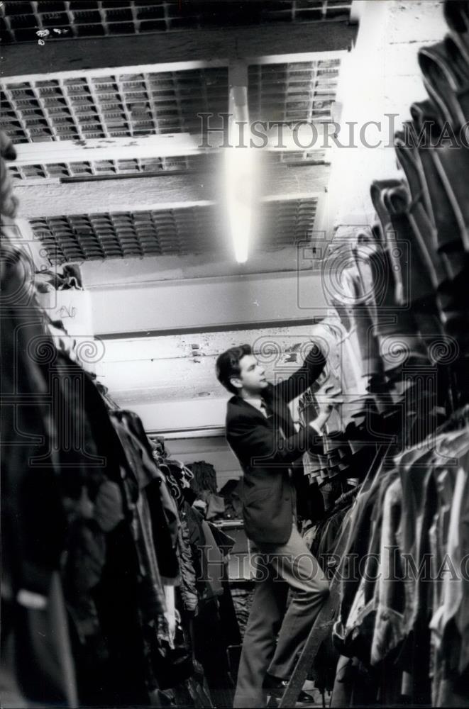 Press Photo Assistant At Brompton Road Branch Goes Through Rows Of Armour - Historic Images