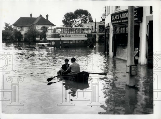 1958 Press Photo Two People Row Past Marooned Bus Car Flooded Wickford Essex - Historic Images