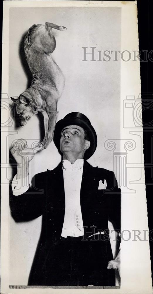 1957 Press Photo Dog Balances On Man's Thumb In Frankfurt Germany - Historic Images