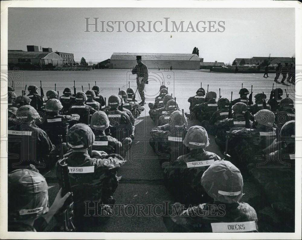 Press Photo Seated Troops With Their Guns Listen To A Speech - Historic Images