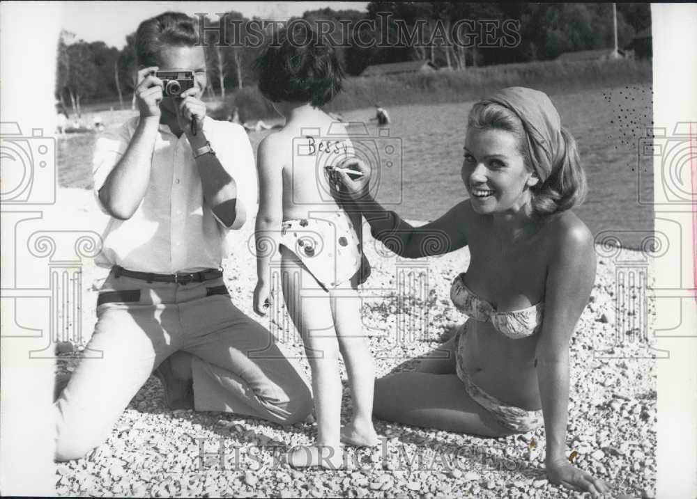 1966 Press Photo Mom Draws on Daughter&#39;s Back. Family Vacation. Germany. - Historic Images