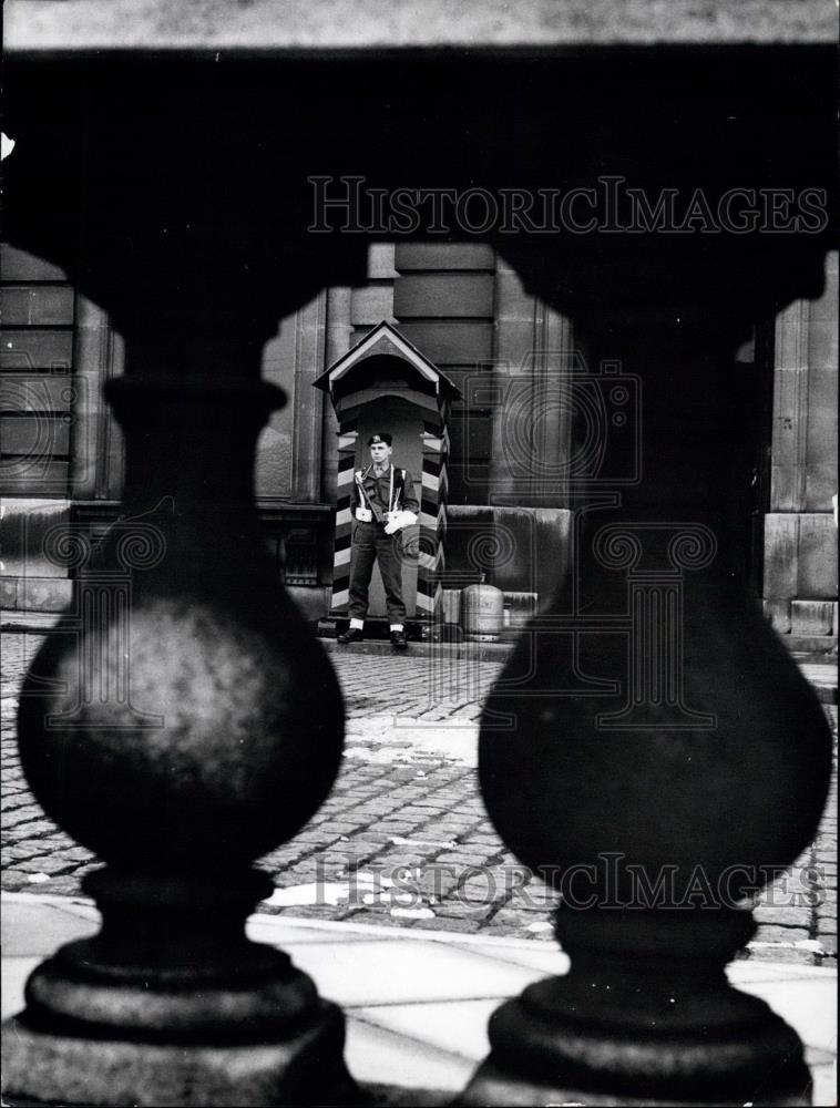 Press Photo Guard standing watch on cobblestone street - Historic Images