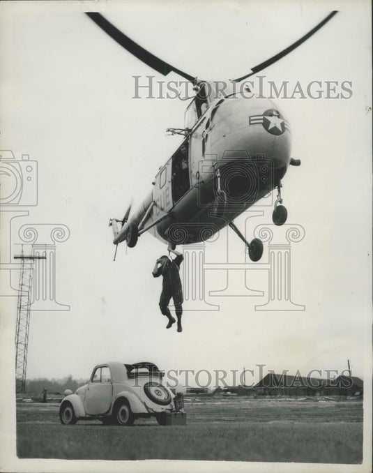 1954 Press Photo Airman lowered into a car from a helicopter - Historic Images
