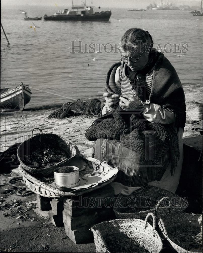 Press Photo Lisbon fish wife sews her shawl while waiting for fish - Historic Images