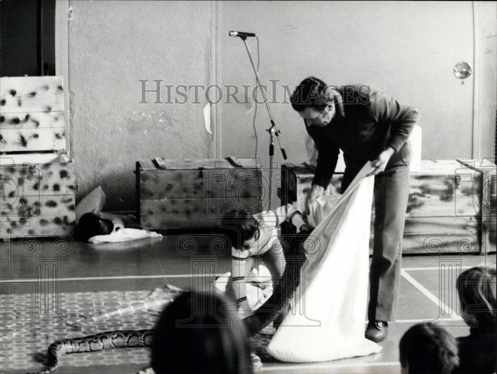 Press Photo A Child Helps Put A Snake In A Bag - Historic Images