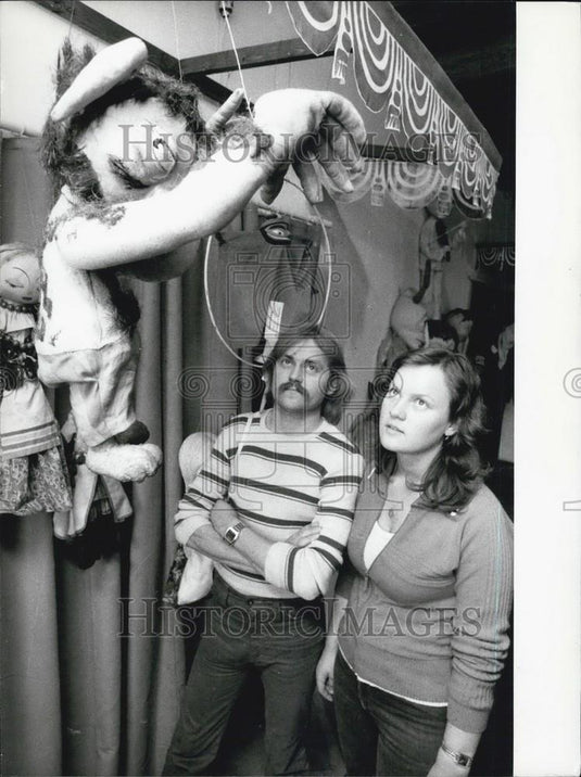 Press Photo man and woman staring up at animal based puppet - Historic Images