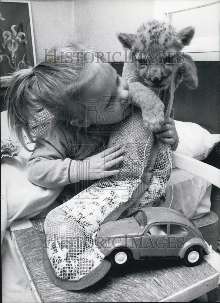 Press Photo A Baby Plays With Her Animal, A Stocking &amp; A Car - Historic Images