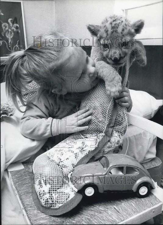 Press Photo A Baby Plays With Her Animal, A Stocking & A Car - Historic Images