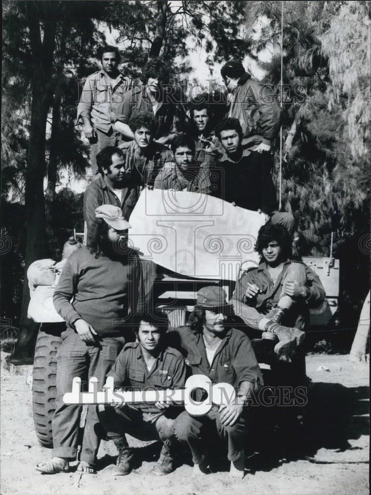 Press Photo Men Gather Around A Vehicle With A Large Key - Historic Images