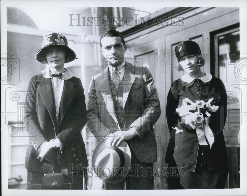Press Photo A Man Holding His Hat Stands Between Two Women Next To A Train - Historic Images