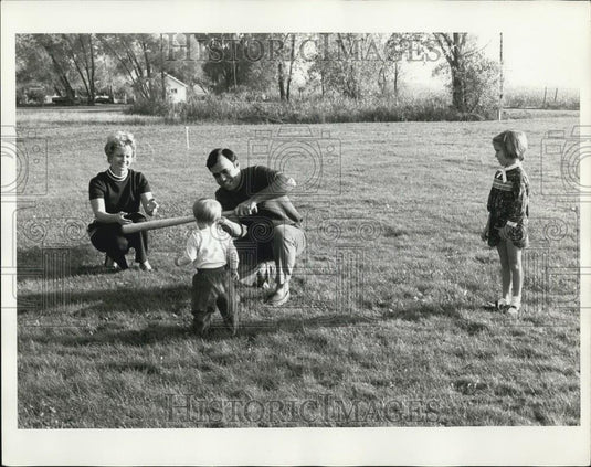 Press Photo A Family Teaching A Toddler To Play Baseball - Historic Images