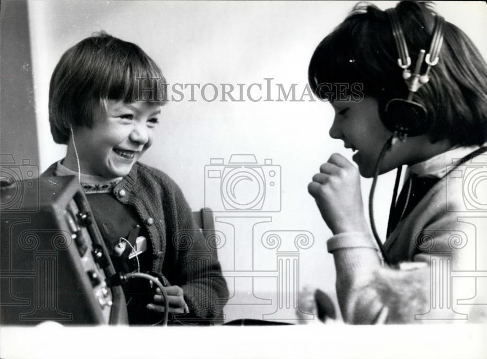 Press Photo Children Talking to Each Other Via Headphones - Historic Images