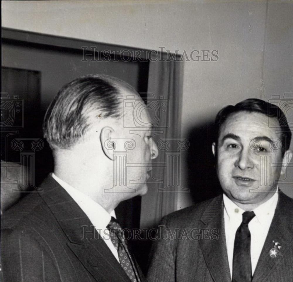 Press Photo Two men in suits having a conversation - Historic Images