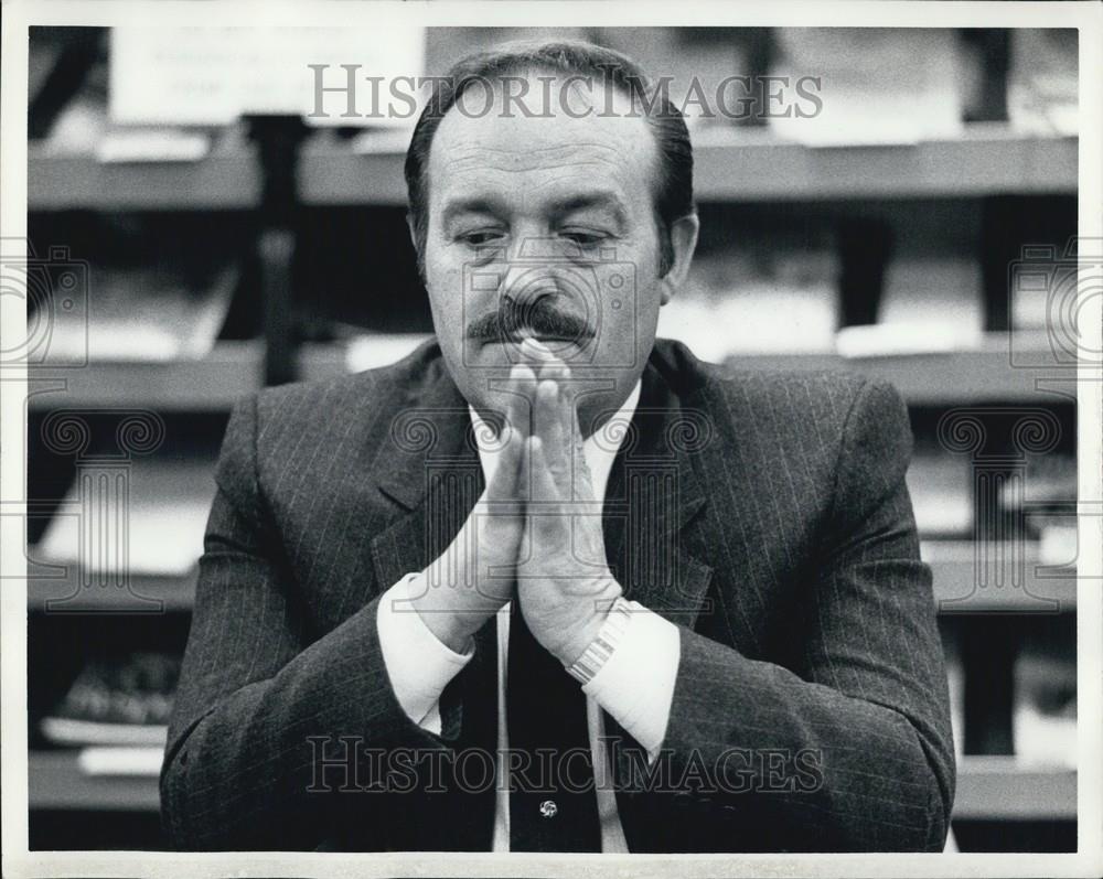 Press Photo A Man In A Suit Presses His Hands Together And Thinks - Historic Images